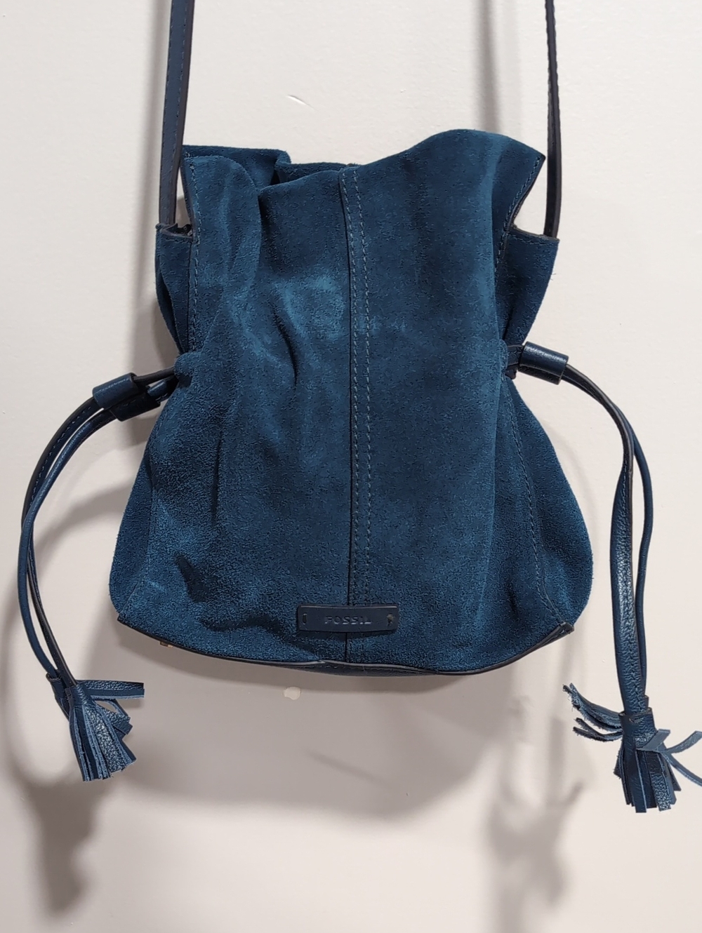 Fossil Blue Suede Bucket Bag with Drawstring Closure And Tassel Details.